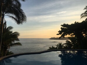 Ein Pool mit Blick auf den Ozean und eine entfernte Küstenlinie.