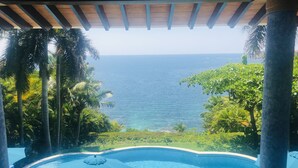 A view from a covered pool area with a clear view of the ocean. - Exclusive Villa with Private Beach and Beautiful  Views to the Pacific Ocean (Bahías de Huatulco)
