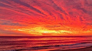 A sunset over the ocean with a vibrant sky. - Sunset Joy - KDH MP 6, Soundfront, Sound View, Kayak, Community Boat Ramp, Pets OK, Flex Stays (Kill Devil Hills)