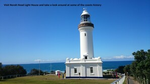 A white lighthouse with a clear view of the ocean and a clear sky.