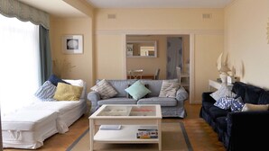 Una sala de estar con una cama, dos sofás, una mesa de centro y un comedor.