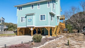 A two-story building with a blue exterior and a wooden deck. - Duck R Way - Poteskeet, Ocean View, 260 Yds to Beach, Pool, Hot Tub, Walk to Downtown Duck (Duck)