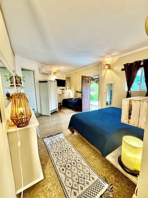 A room with a bed, a desk, a lamp, and a window with curtains.