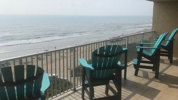 A balcony with chairs overlooking a beach. - Cozy BeachFront Condo with Oversized Balcony and Amazing Views (South Padre Island)