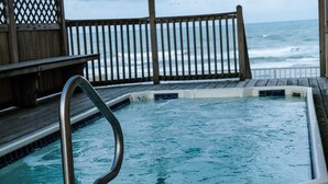 A wooden deck with a hot tub overlooking the ocean. - Cozy BeachFront Condo with Oversized Balcony and Amazing Views (South Padre Island)