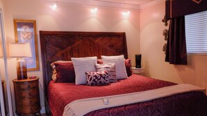 A bedroom with a large bed, a nightstand, a lamp, and a wall-mounted TV. - Cozy BeachFront Condo with Oversized Balcony and Amazing Views (South Padre Island)