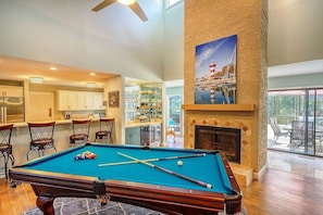 A pool table in a spacious room with a fireplace and a painting of a lighthouse. - SEA PINES, RECENTLY UPDATED, PRIVATE POOL, GAME ROOM FOR ADULTS AND KIDS (Hilton Head Island)