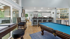 Een moderne keuken met een pooltafel, bar en eethoek.