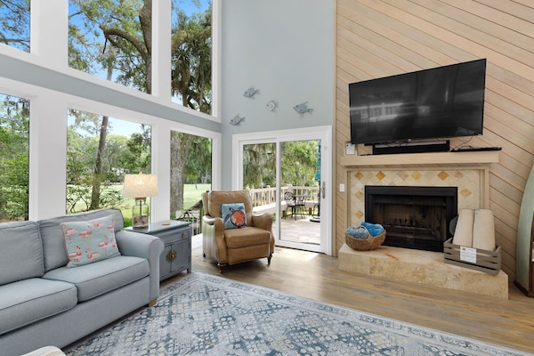 Spectacular living room with a wall of windows. It has 2 sofas & 3 recliners with a 65" 4K TV & Sonos sound system. It's the perfect place to watch nature or a movie after a day at the beach!