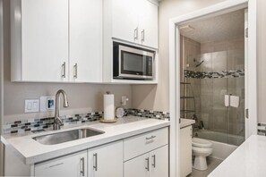 Et moderne badeværelse med bruser, toilet og indbygget mikroovn.