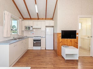 A compact kitchen with a microwave, stove, and refrigerator. - Moruya Holiday Park (Moruya)