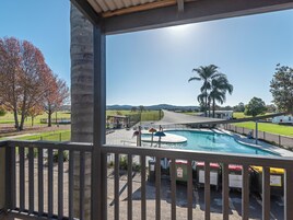 Un espace piscine offrant une vue sur le paysage environnant, notamment les arbres et les collines.