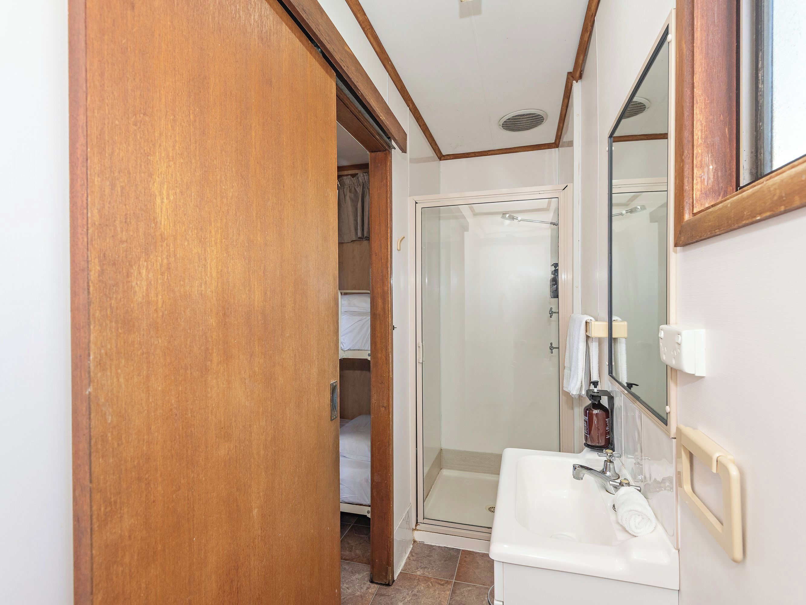 A bathroom with a shower, a sink, and a mirror.