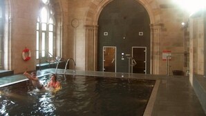 Ein Innenpool mit Steinwänden, großen Fenstern und einem Rettungsring.