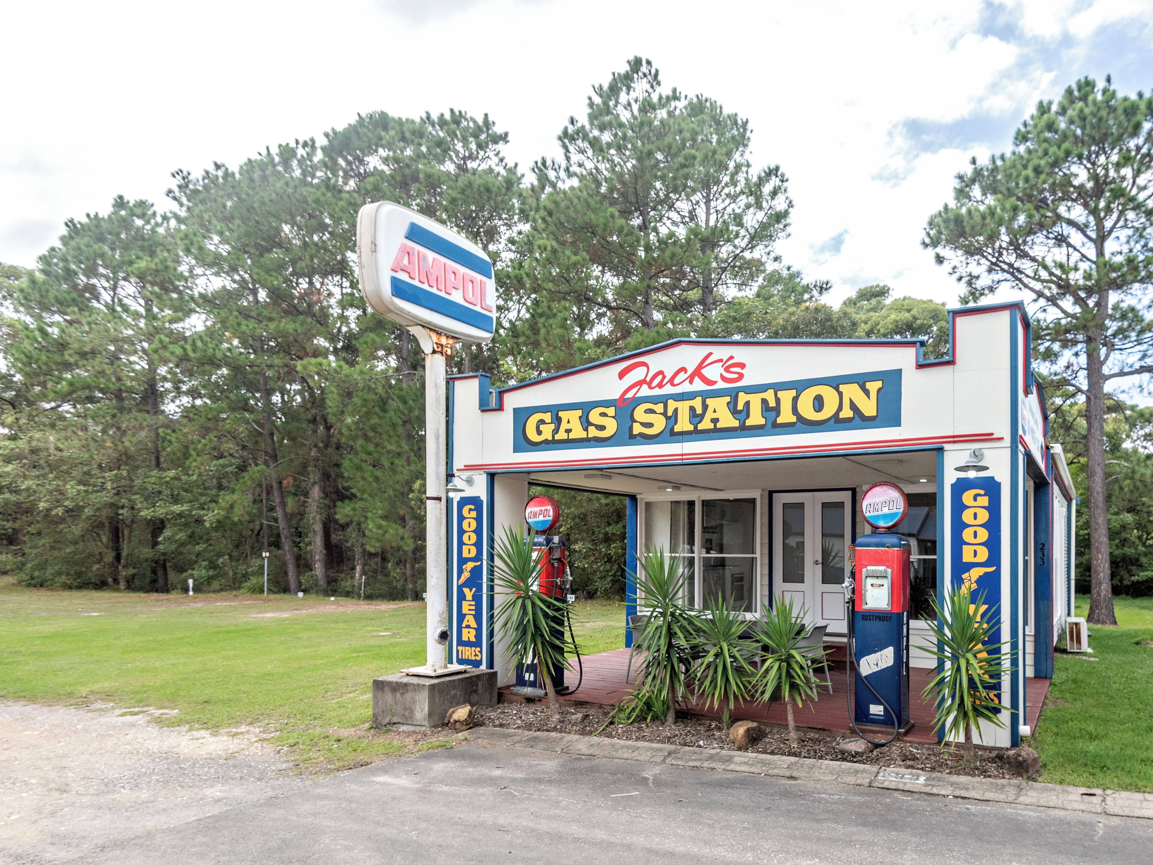 A small, standalone gas station with a sign reading 'Jack's Gas Station' and a 'Good Year Tires' advertisement.