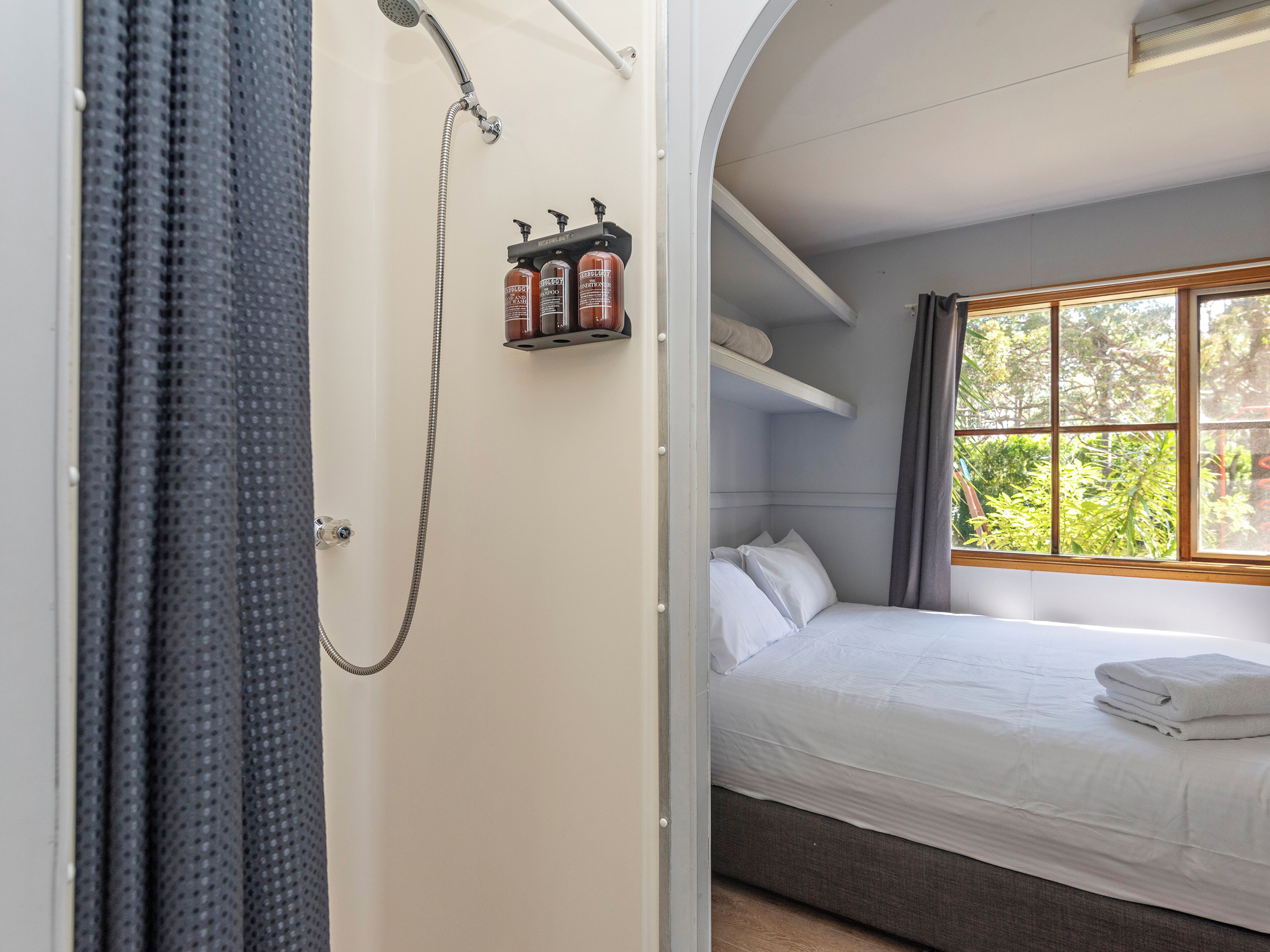 Ein Schlafzimmer mit Bett, Dusche und Fenster.