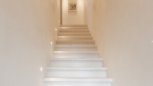A white staircase in a hallway with wall-mounted lighting fixtures. - Ca' Dell'Opera Terrace (Venice)