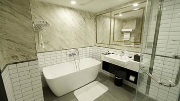 Un baño moderno con una bañera independiente, ducha con cerramiento de vidrio y un espejo grande.