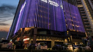A modern hotel building with a prominent "JAZZ HOTEL" sign, featuring vertical lighting and a sleek design. - Jazz Hotel Penang (George Town)