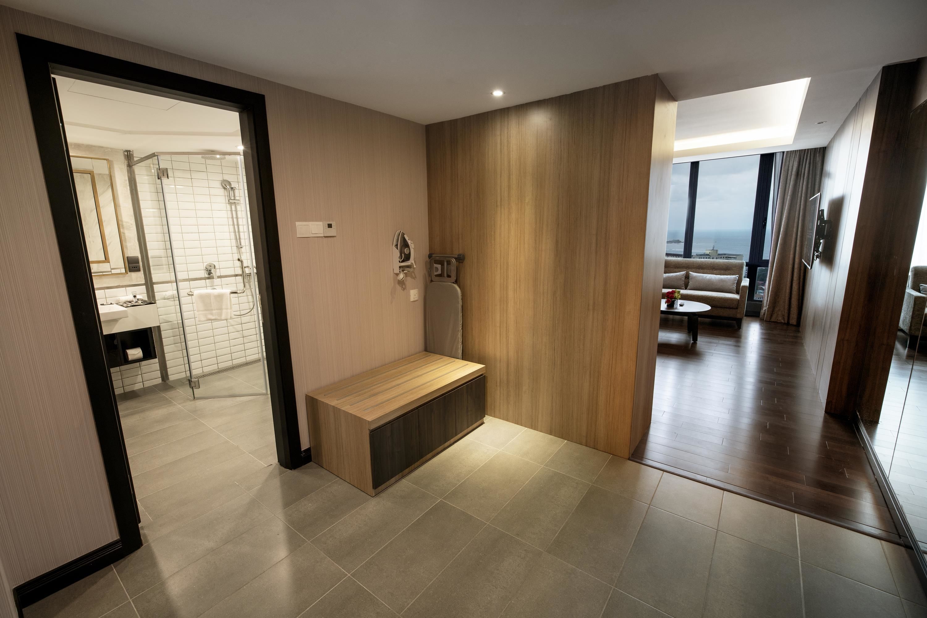 Un baño moderno con ducha, banco y vistas al área de estar.