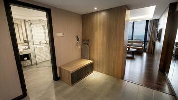 Un baño moderno con ducha, banco y vistas al área de estar.