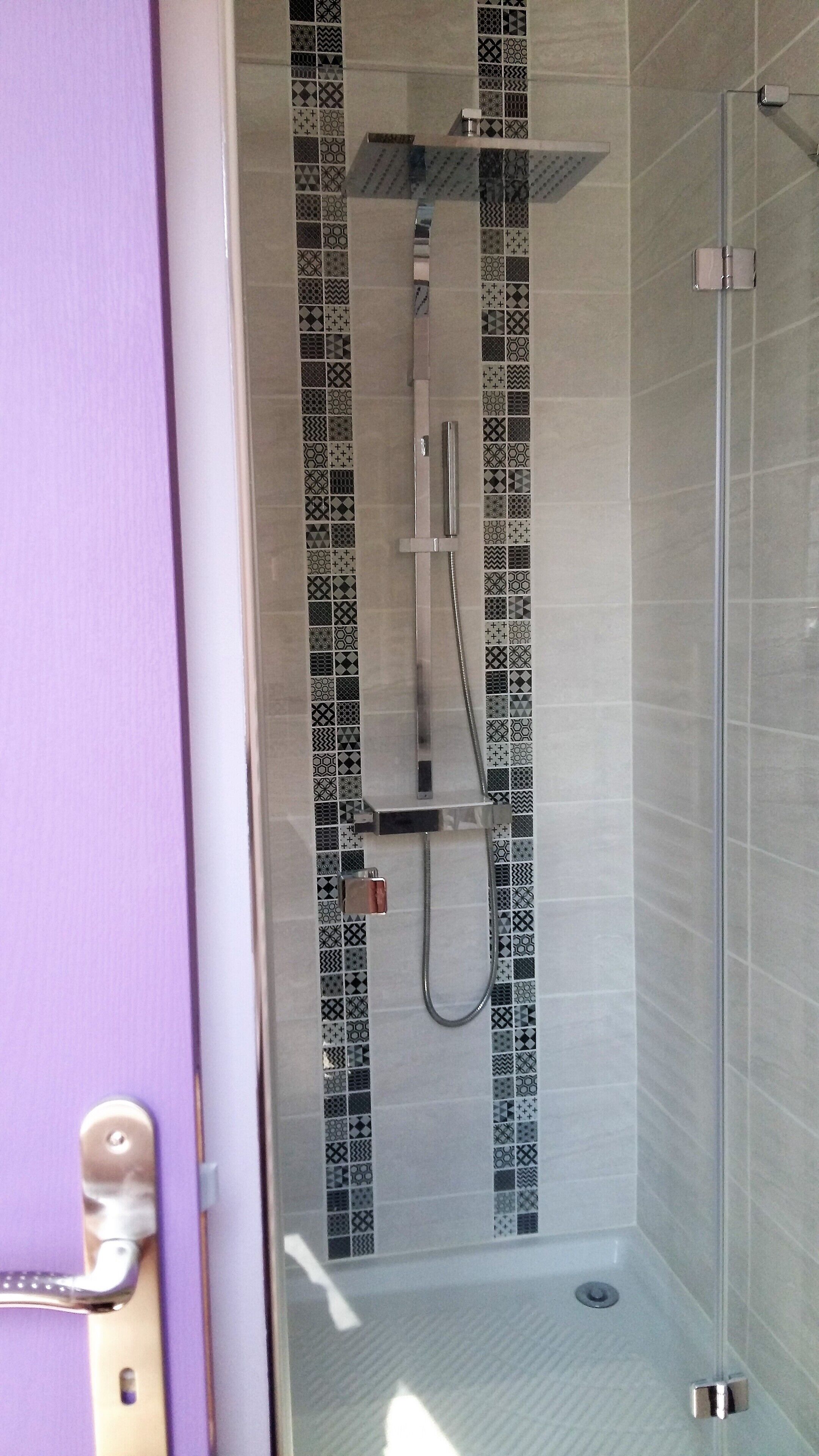 Doccia con porta in vetro, soffione a mano e pannello comandi a parete.