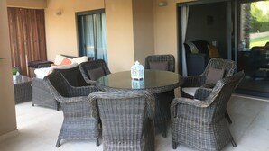 A round table with wicker chairs, a glass top, and a bottle of water. - 3 Bed Apartment Rental w/ Pool nr Beaches, Golf in Vilamoura, Algarve, Portugal (Vilamoura)