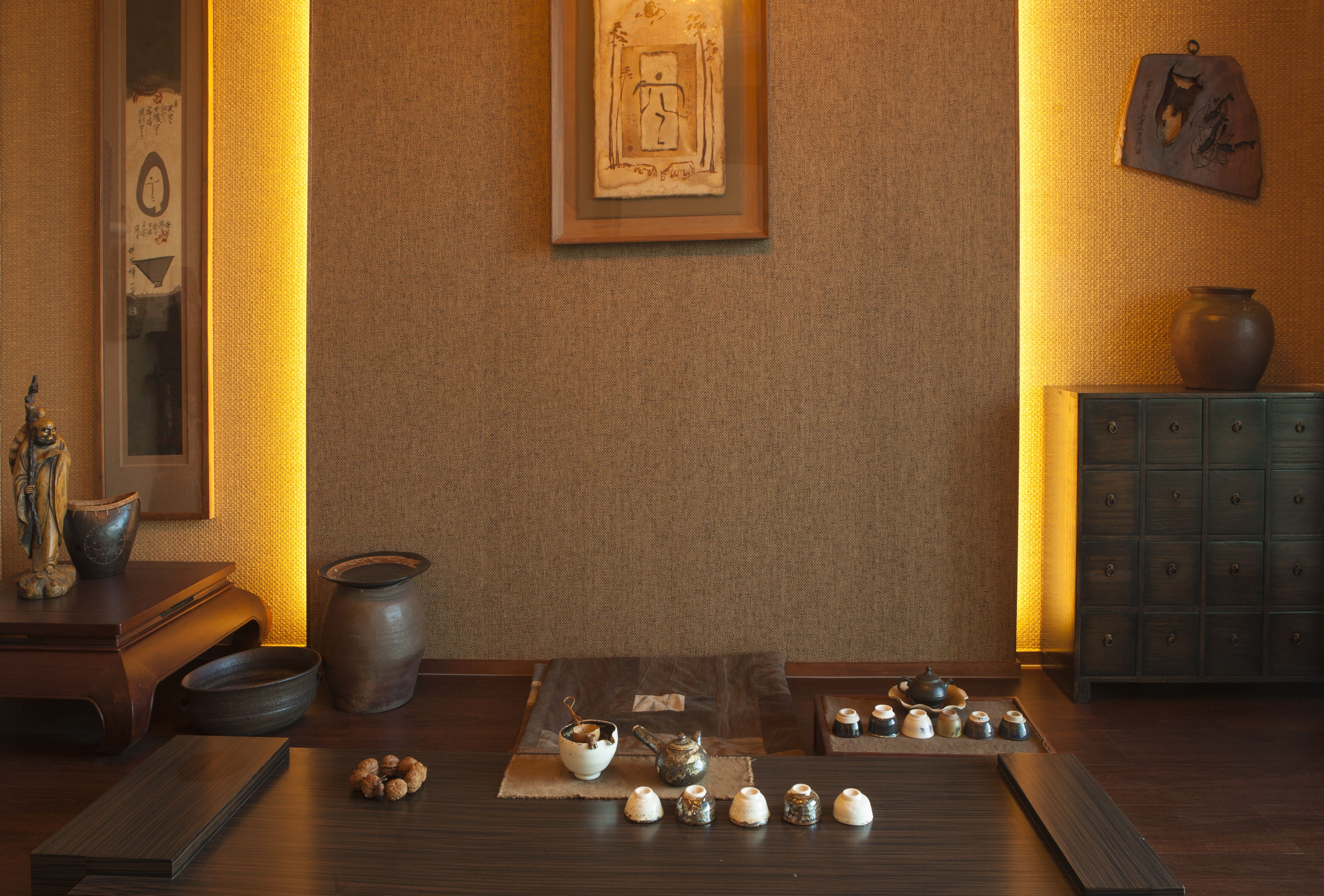 Ein traditionell eingerichtetes Zimmer mit Tatami-Matte, Teeset und einem Schrank mit einer Vase.