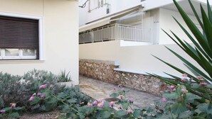 Un edificio de dos pisos con un muro de piedra y un balcón.