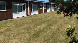 A row of single-story mobile homes with a grassy lawn in front. - LEE'S CHALET, NORTON PARK, Dartmouth, 2 bedrooms, sleeps 4 (Dartmouth)