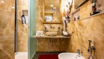 Une salle de bain moderne avec un meuble-lavabo en marbre, un grand miroir et une cabine de douche en verre.