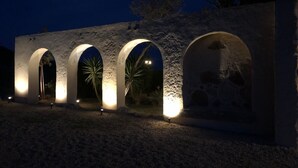 A building with three illuminated arches at night, under a moonlit sky. - ALQUERIA DE GÍTAR. Beautiful rural villa for 20 people close to the sea (Felix)