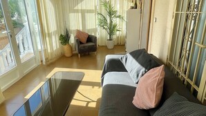 Una sala de estar con un sofá, una mesa de centro y una planta en maceta.