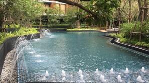 A swimming pool with a waterfall feature and a surrounding garden. - Secret Mori Hotel (Bangkok)