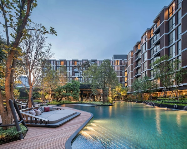 Alberca al aire libre, sombrillas en la alberca y camastros