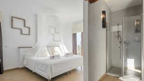 Une chambre avec un lit sous un baldaquin blanc, une salle de douche avec une porte en verre et une vue sur l’extérieur.