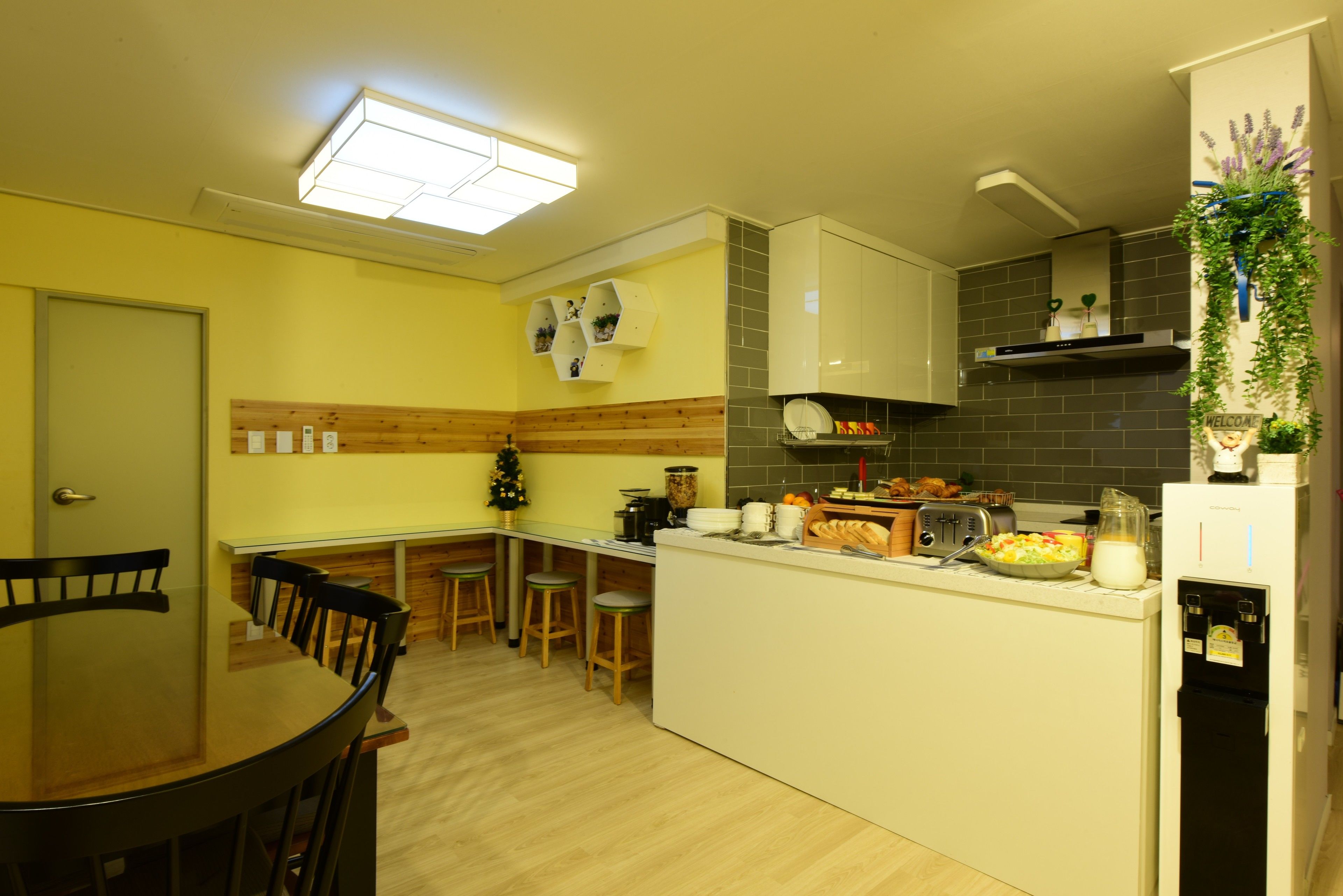 Una cocina compacta con comedor, que incluye una isla central, taburetes de madera y un refrigerador empotrado.