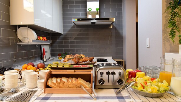 A breakfast buffet with various food items, a toaster, and a salad bowl. - DAOL guest house (Seoul)
