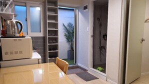 A compact kitchen with a dining area, a built-in shoe rack, and a shower room. - DAOL guest house (Seoul)