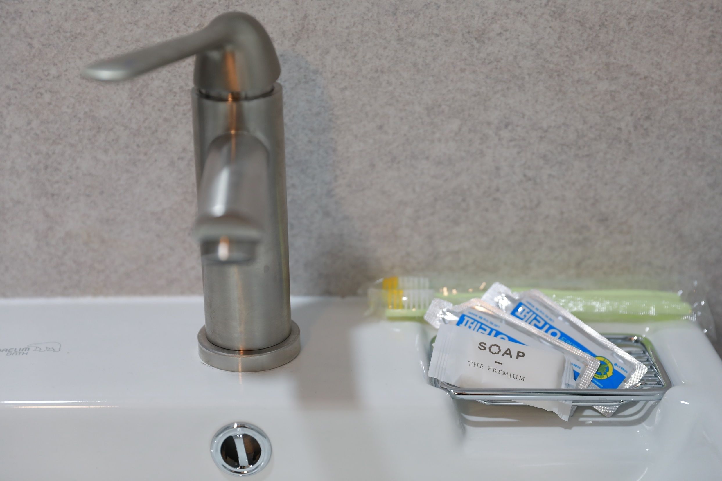 A bathroom sink with a faucet and soap packets.