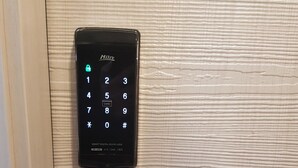 A smart digital door lock with a keypad and a keyhole below it. - Dawoo House - Hostel (Seoul)