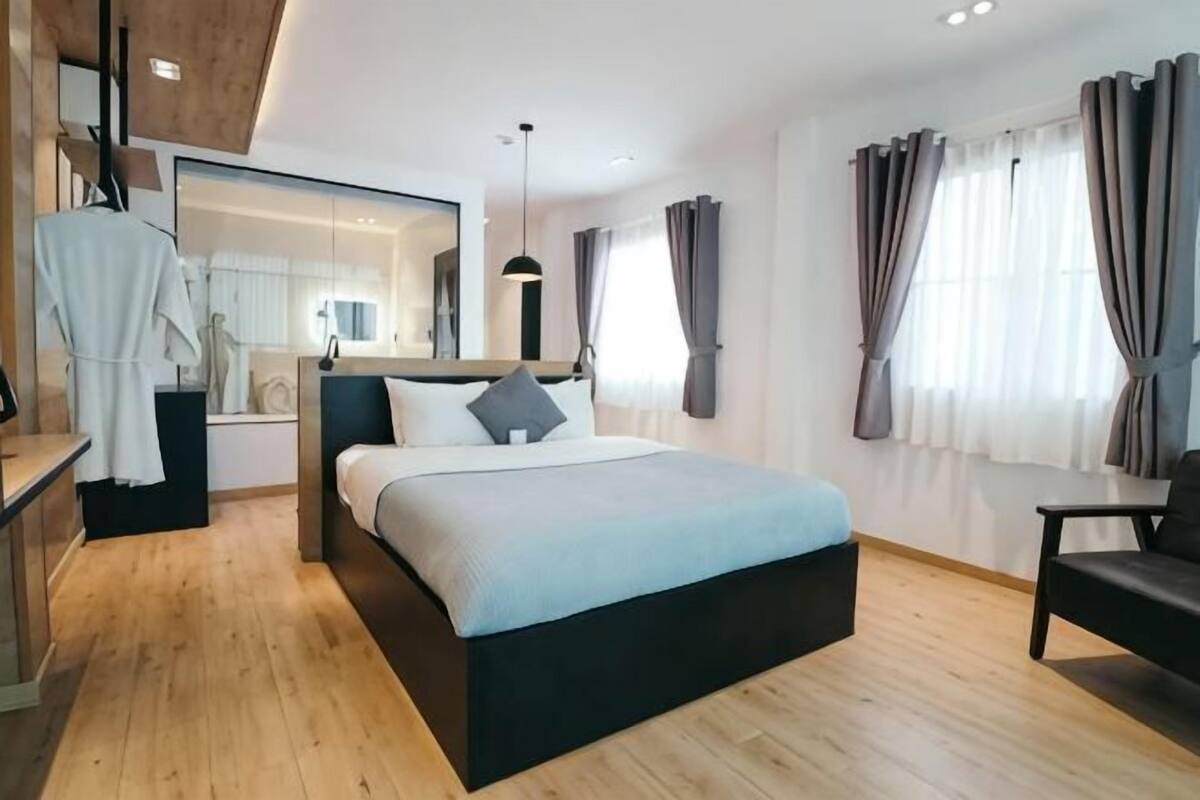 Une chambre à coucher moderne avec un lit, une table de chevet et un miroir.