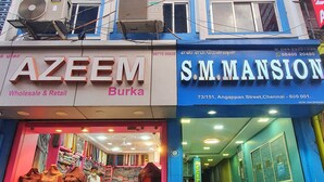 Un edificio con varios negocios, incluyendo AZEEM Wholesale & Retail y S.M. MANSION.