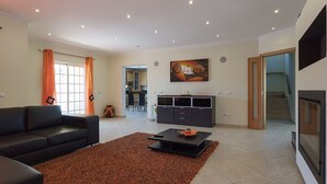 Ein Wohnzimmer mit schwarzem Sofa, Couchtisch und einem Gemälde an der Wand.