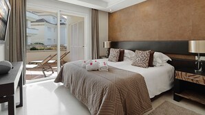 A hotel room with a large bed, a desk, and a balcony with outdoor furniture. - 322 Luxury Apartments-Estepona, 2 b'room Apt, 28c All Year 20m Heated Pool (Estepona)