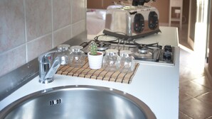 A kitchen with a stainless steel sink, a stove, and a toaster. - Villa INN Costa Casa Ravello (Tramonti)