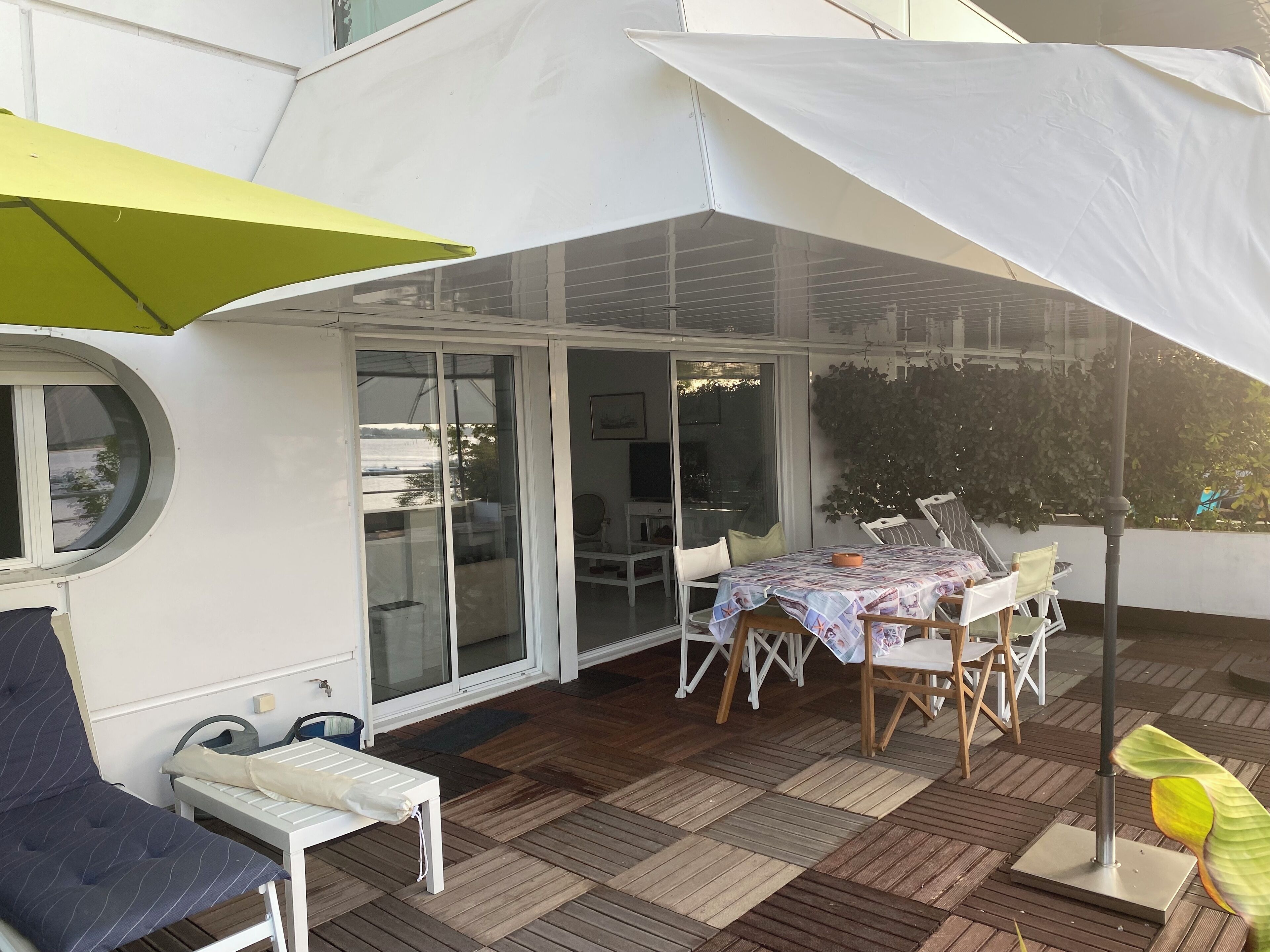 A covered outdoor area with a table and chairs, a bench, and a large umbrella.