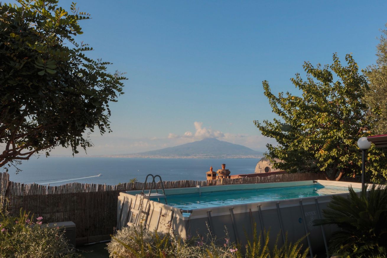 Una piscina con vista su una montagna e il mare.
