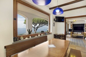 A dining area with a large window, wooden bench, and a table.