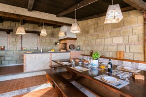 A rustic dining area with a brick wall, wooden beams, and hanging pendant lights. - MyExclusiveItaly - Luxury Villa with breathtaking Seaview,pool,BBQ (Sorrento)
